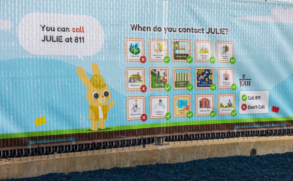 fence wrapping showing a rabbit that says "you can call julie at 811"