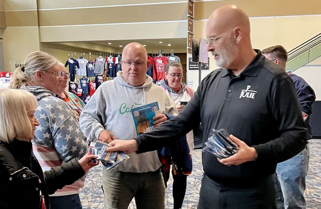 A JULIE employee hands some pamphlets to a fan