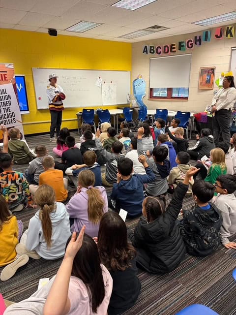 A classroom with students raising their hands